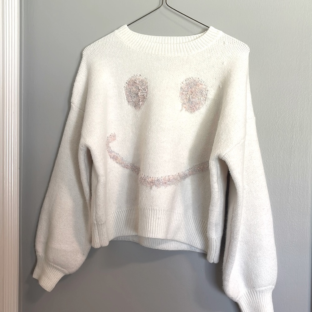 It’s a loose fitting smiley face sweater
